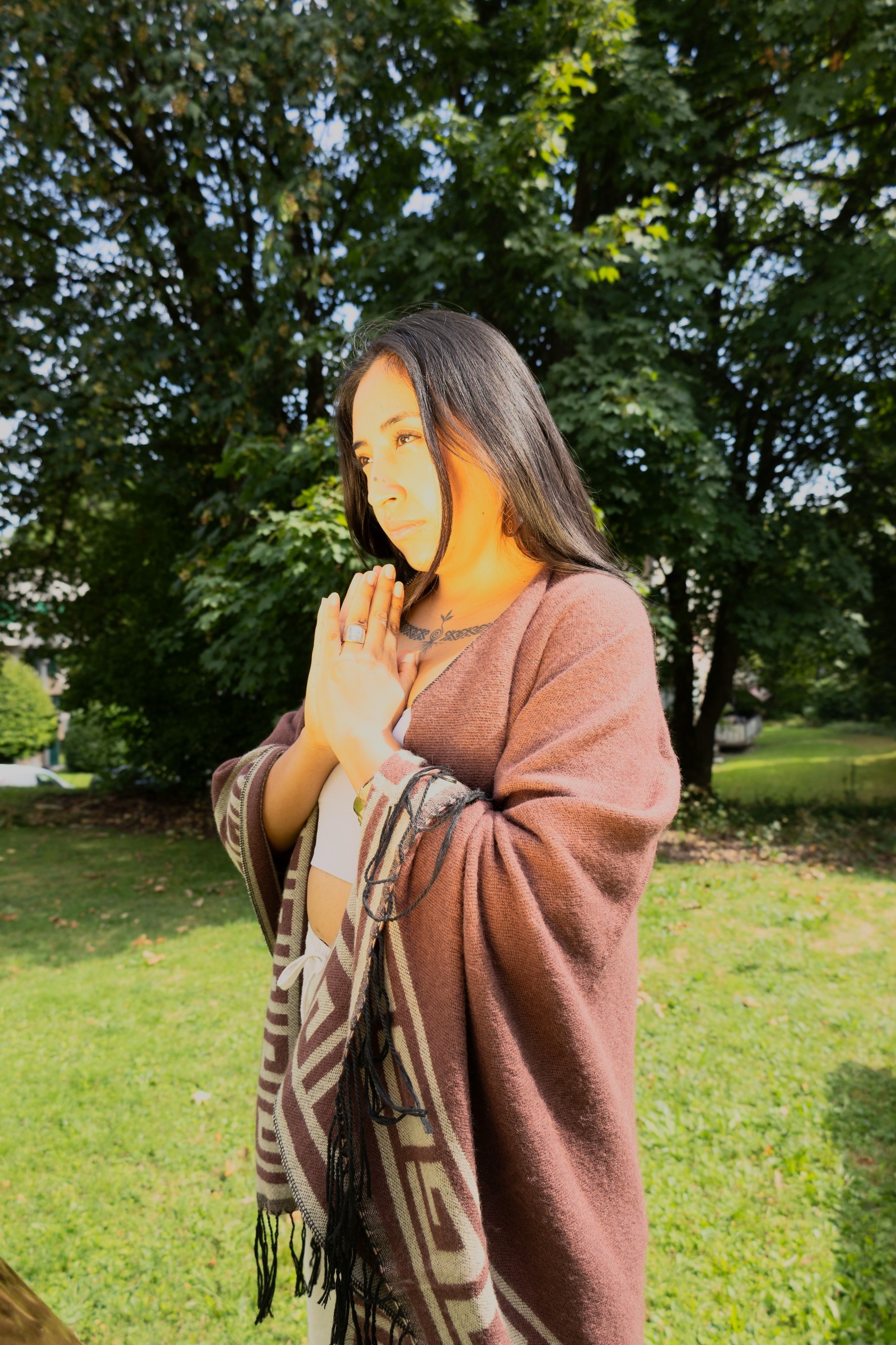 Devi de perfil con las manos en gesto de gratitud, luz dorada